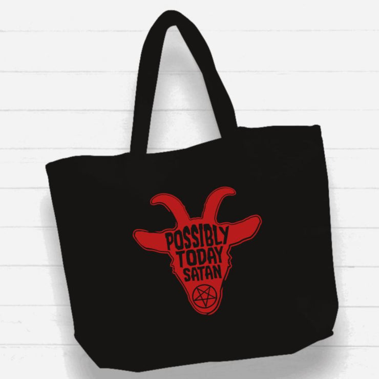 Black tote bag with red goat graphic and text on a white wooden background