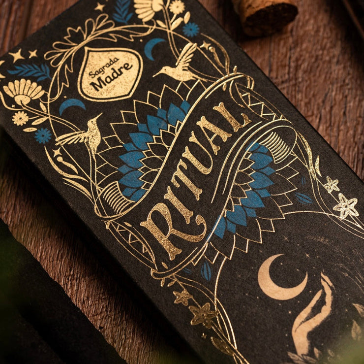 Decorative box with intricate designs and 'Ritual' text on a wooden surface
