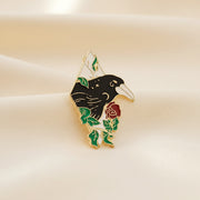 Pin with a design of a hand holding a rose on a dark surface