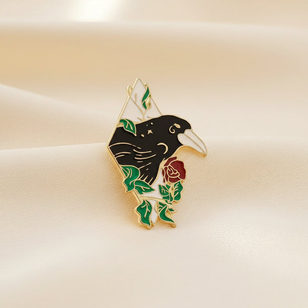 Pin with a design of a hand holding a rose on a dark surface