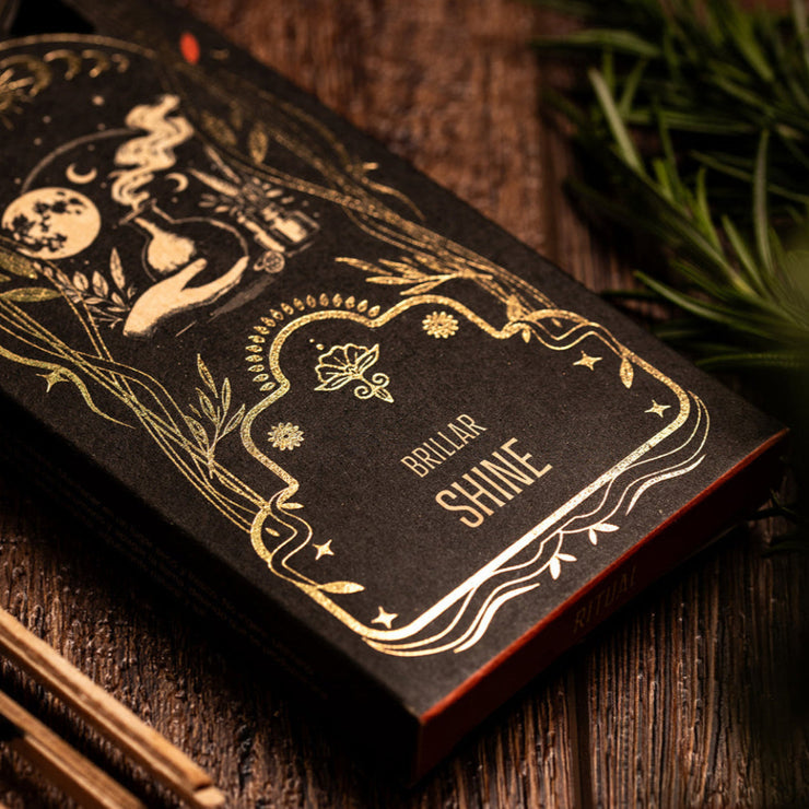 Black and gold product packaging with 'Shine' labeling on a wooden surface.