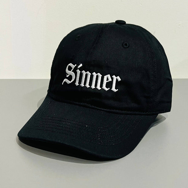 Black cap with 'Sinner' text on a white background