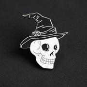 The Skull in Witch Hat Enamel Lapel Pin by Bleak Boutique features a cartoon-style skull with a pentacle-adorned witch hat on a gray textured background—an ideal spooky accessory for your collection.