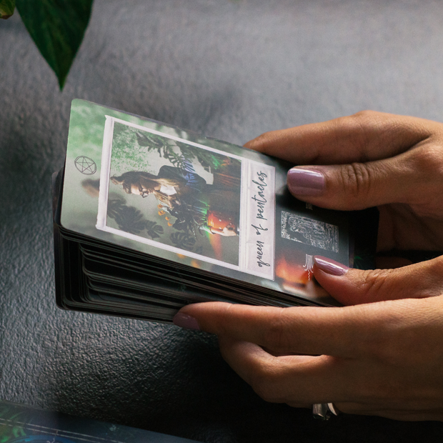 Person holding a deck of cards with a scenic design on a textured surface