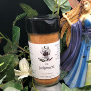 Jar of Tarot Card Spice Blend "Judgement" by Dahlia's Enchanted Kitchen surrounded by foliage and next to a fairy statue