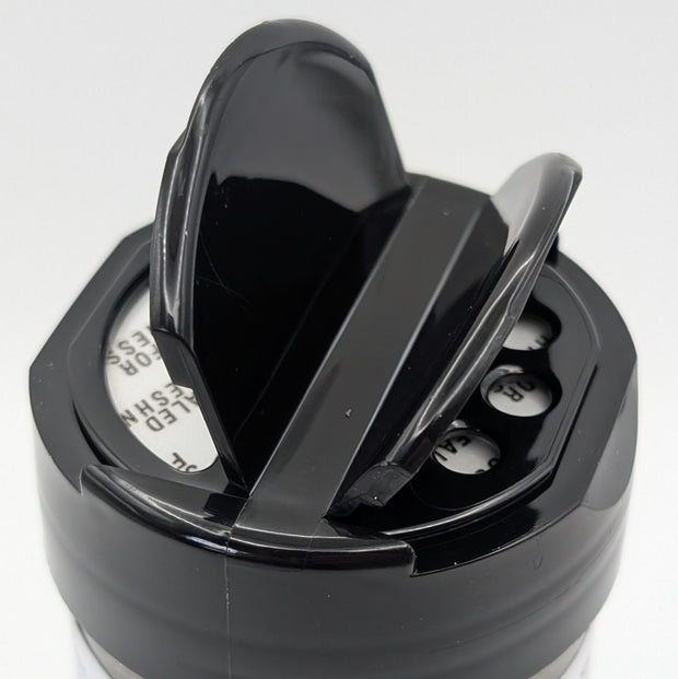 Black jar lid showing two different openings on a white background.