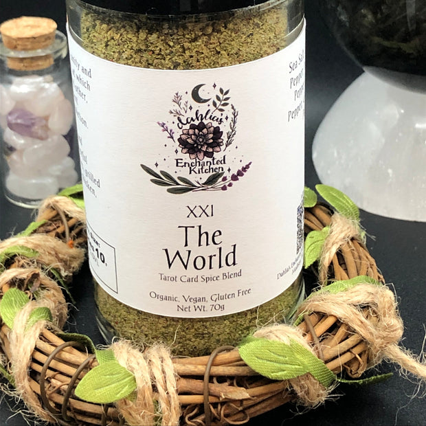 A Jar of Tarot Card Spice Blend "The World" by Dahlia's Enchanted Kitchen surrounded by decorative elements on a dark background