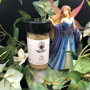 Spice jar labeled 'The Fool' with a fairy figurine among greenery