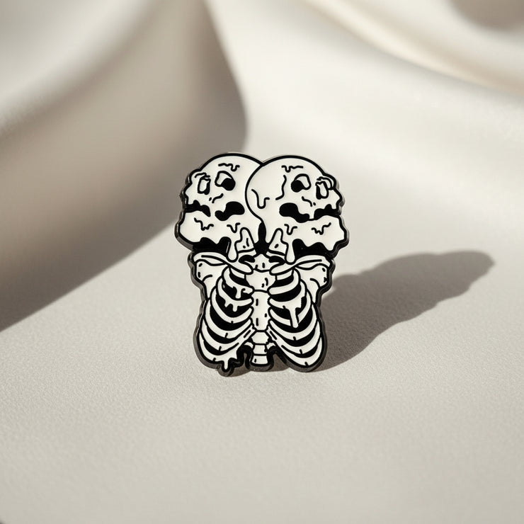 Two Heads Enamel Lapel Pin depicting a skeleton with two heads on a light background