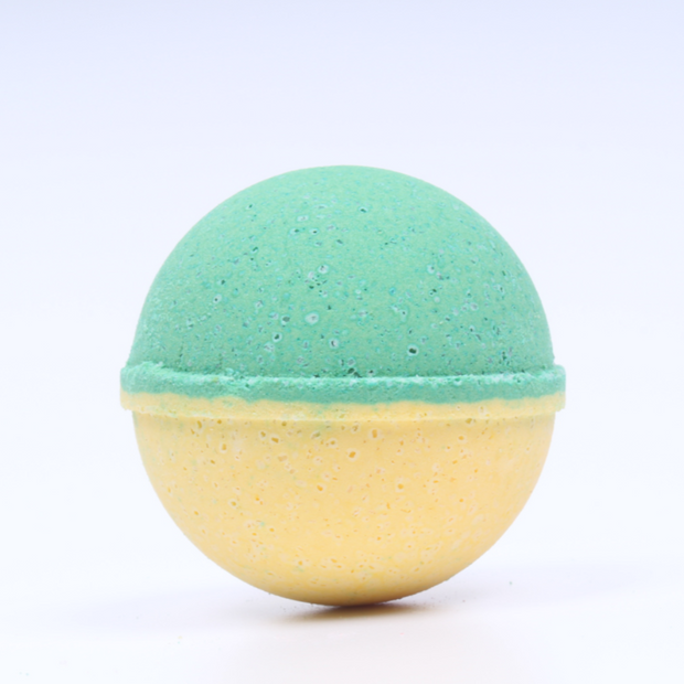 Two-toned green and yellow bath bomb on a light gray background