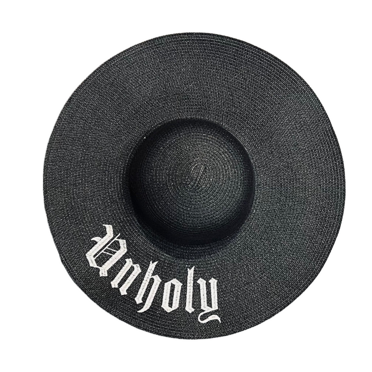 Black straw hat with 'Unholy' text on a white background