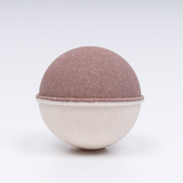 Round bath bomb with a two-tone design on a white background