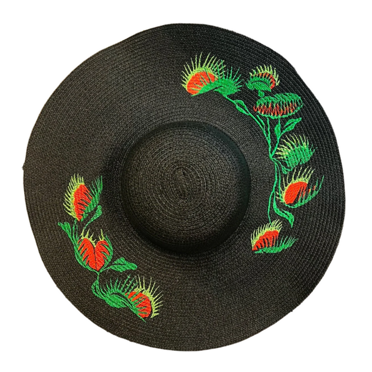 Black straw hat with green and red Venus fly trap embroidery on a white background