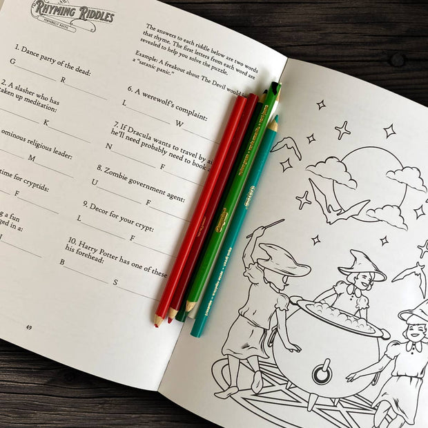 Open book with coloring page and pencils on a wooden surface