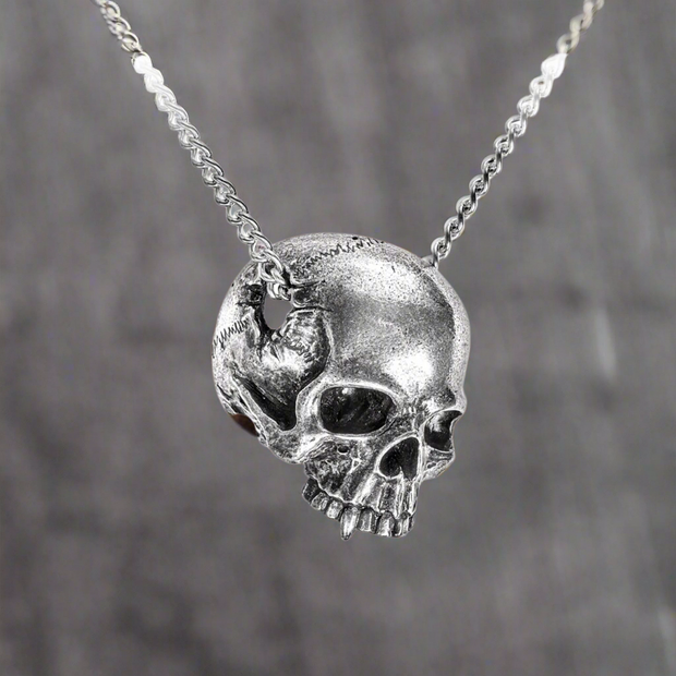 Nosferatu's Lament Skull Necklace by Alchemy Gothic featuring a jawless human skull with a vampiric canine tooth, presented in a ¾ view, with a large temporal perforation for the pendant chain.