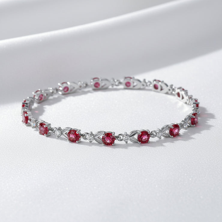Silver bracelet with red gemstones on a white background