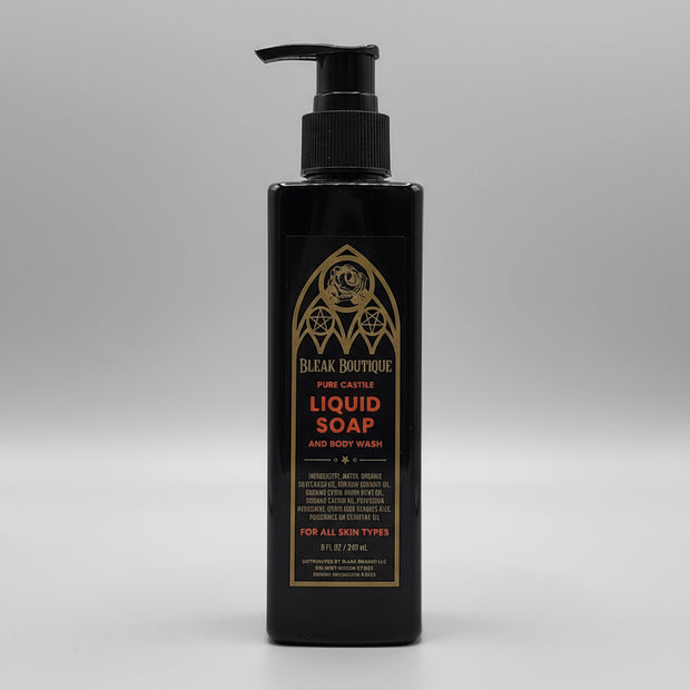 Black bottle of liquid soap with gold text on a metallic surface