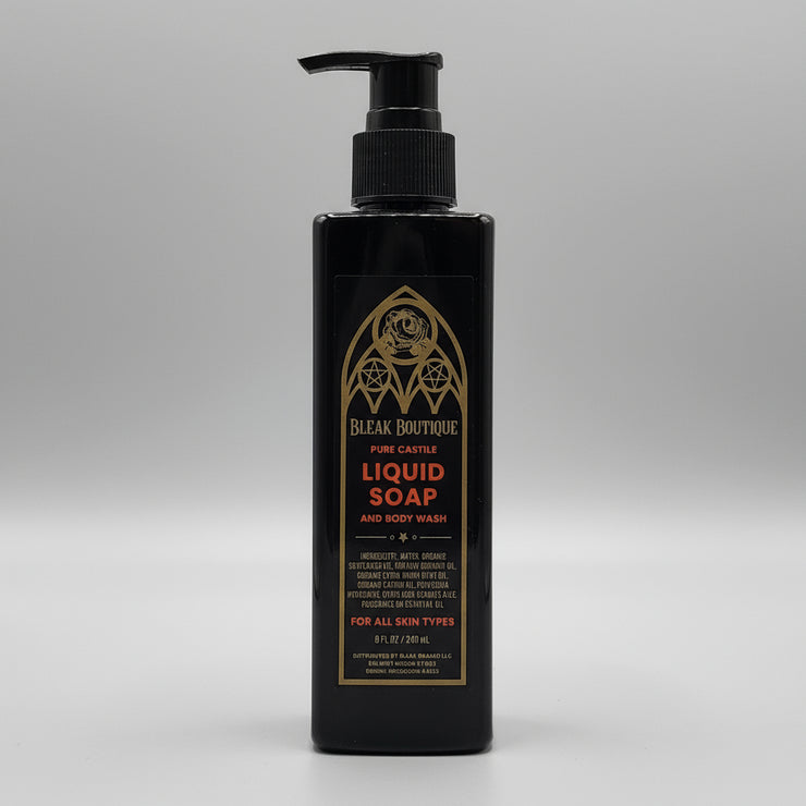 Black bottle of liquid soap with gold text on a metallic surface