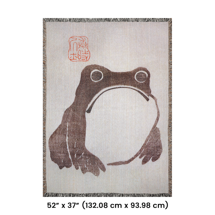 Frog by Matsumoto Hoji Woven Throw Blanket from Meika Gafu, 1814, featuring a sad-faced frog in black ink beneath red calligraphy. This Zen-inspired design was common during the Japanese Edo period, representing a pure and natural life.