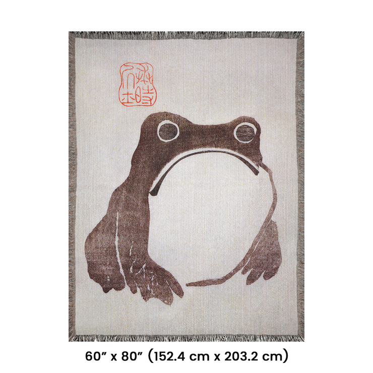 Frog by Matsumoto Hoji Woven Throw Blanket from Meika Gafu, 1814, featuring a sad-faced frog in black ink beneath red calligraphy. This Zen-inspired design was common during the Japanese Edo period, representing a pure and natural life.