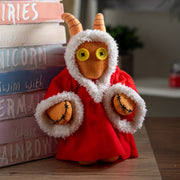 Stuffed toy with horns and red outfit on a wooden surface