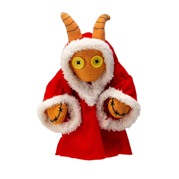 Toy figure of a Krampus in a red outfit with horns on a white background