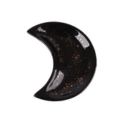 The Crescent Moon Ceramic Jewelry Valet Dish by Bleak Boutique features a glossy black crescent moon shape decorated with gold dots and speckles, making it an ideal trinket holder or jewelry caddy.