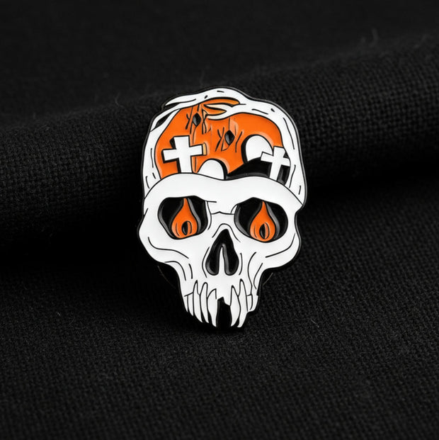 This enamel lapel pin features a human skull with cemeteries on the brain and fire in its eyes, blending gothic symbolism with a touch of dark humor. Rendered in bold enamel and polished metal, the design captures a haunting intensity that’s both eerie and elegant.