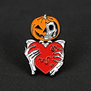 This enamel lapel pin features a spooky skeleton with a jack-o-lantern head, extending a heart in a gesture both eerie and endearing.