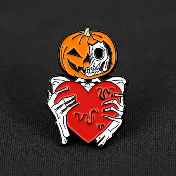 This enamel lapel pin features a spooky skeleton with a jack-o-lantern head, extending a heart in a gesture both eerie and endearing.