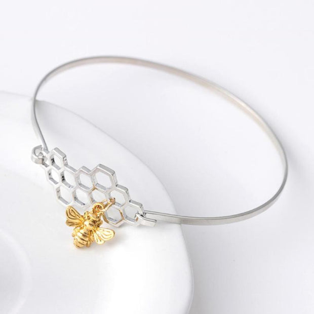 Honeycomb and Bee Silver Bangle Bracelet with Gold Charm on White Background - Unique Gift for Bee Lovers