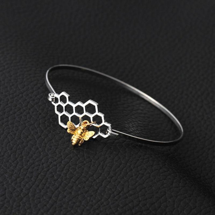 Honeycomb and Bee Silver Bangle Bracelet with Gold Charm on Black Background - Unique Gift for Bee Lovers